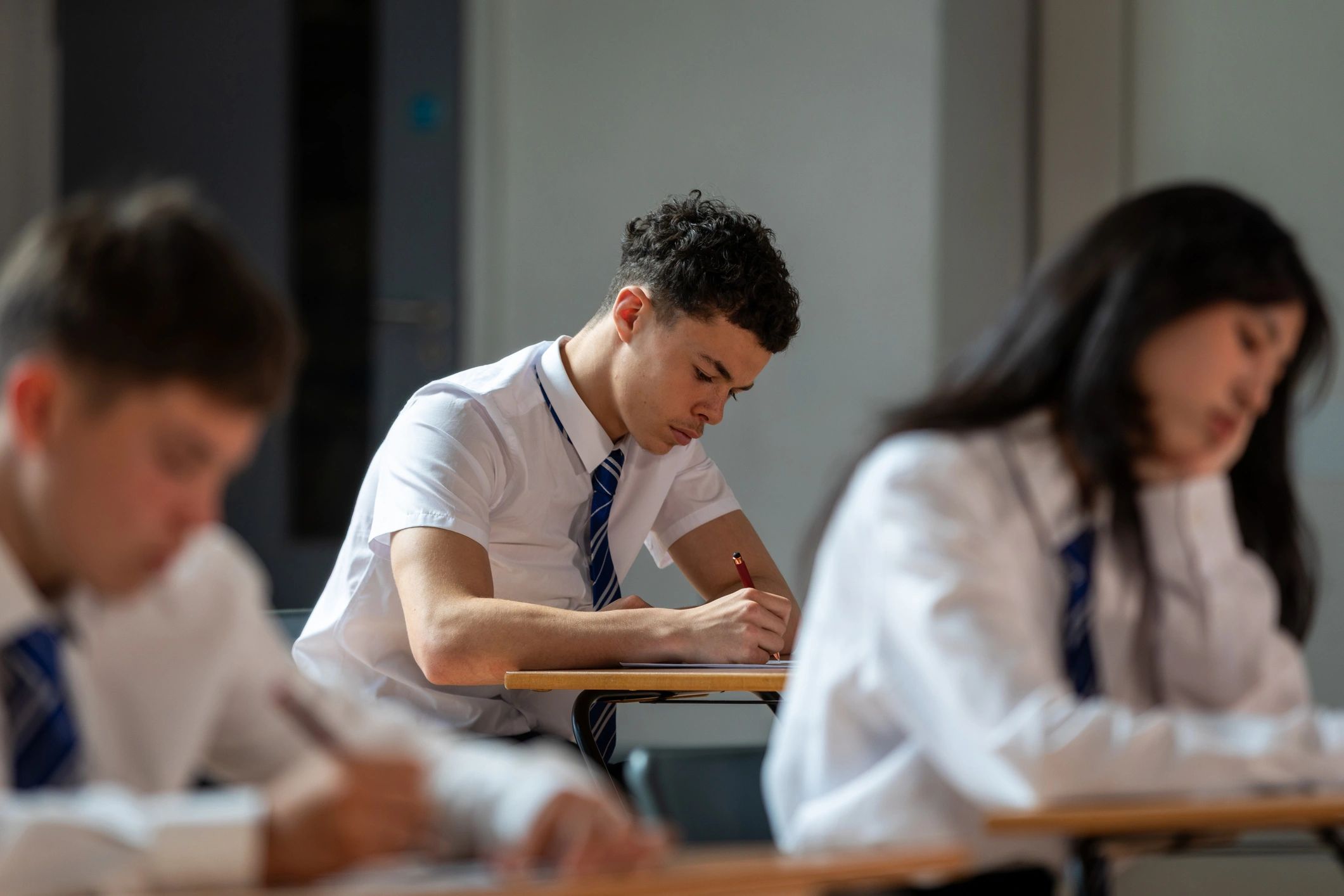 Students completing admission-related paperwork at desks